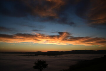Fototapeta premium stunning view of a sunrise between fog ans sky