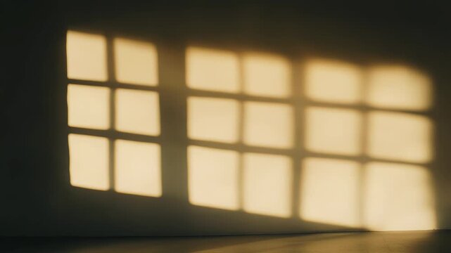 Golden hour sunlight throws a warm grid of window shadows across a minimalist interior wall, creating a serene, geometric pattern and calm atmosphere with ample negative space