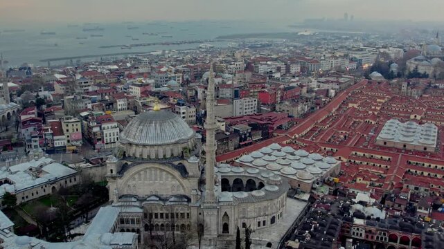 The Nuruosmaniye Mosque in the foreground with the distinctive rooftops of the Grand Bazaar nearby. The Bosphorus and vessels on the sea appear in the background.