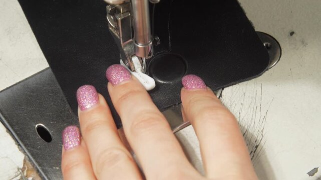 Skilled seamstress operates fabric and machine despite age and scratches from makeshift repairs remains functional and reliable