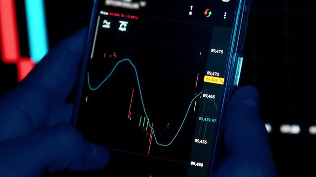 Close up of a man using trading app on a smartphone