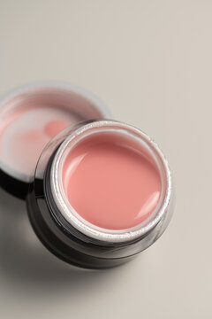 Gel nail extension product with pink polish in jar
