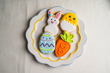 Easter colourful cookies bunny, carrot, egg, chick in a plate, top view