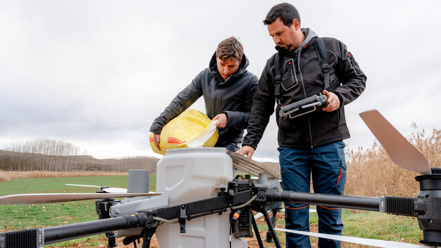 Farmers loading urea into drone solid tank