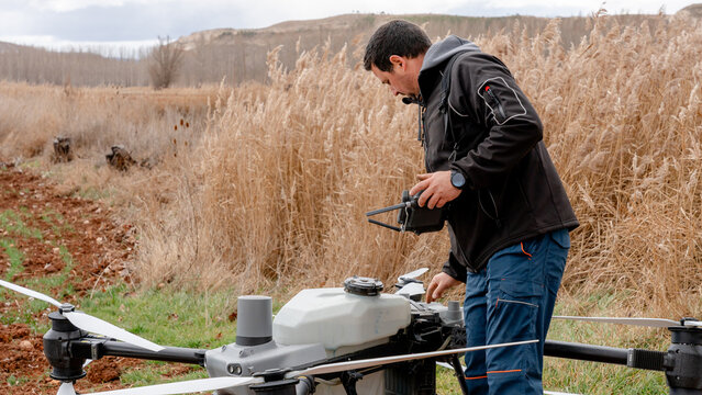 Farmer checking liquid tank of agricultural drone