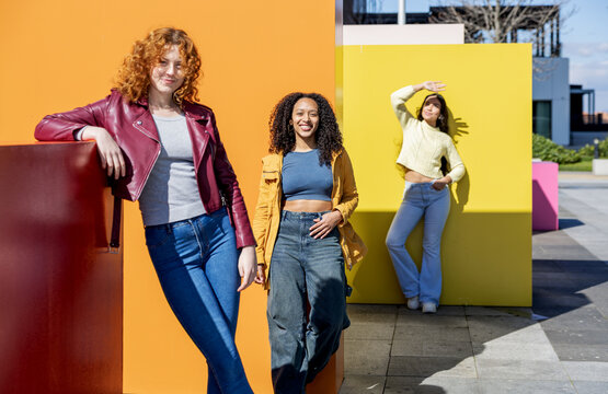 Diverse young women expressing confidence against vibrant color blocks