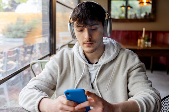Young man freelancing with technology in cafe setting