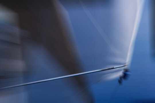 High-angle shot of sailor suspended in the rigging of a maxi yacht. Vintage slide scan and zoom motion blur. Leadership, precision, and the luxury of high-performance maritime sports.