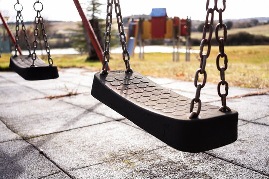 Empty swings in a quiet park on a sunny day