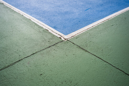 Tennis and basketball court corner with blue and green surfaces