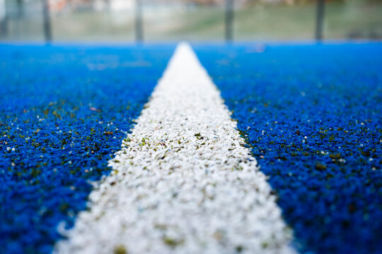Close-up view of padel court with white line on blue surface