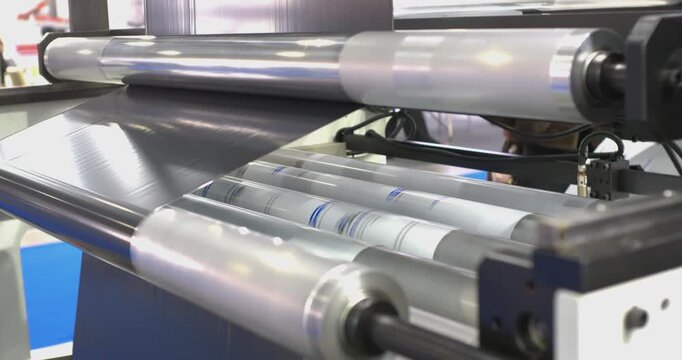 This video demonstrates a specialized machine for manufacturing plastic bags by winding polyethylene film into rolls. The footage captures the automated process of wrapping and packaging the material 