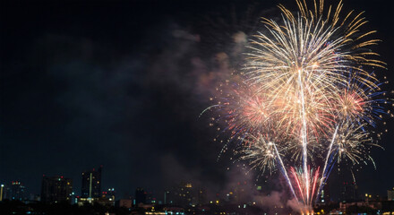Festive golden fireworks in night sky over modern city skyline