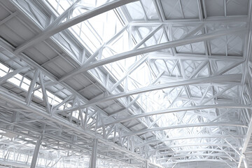 Fototapeta premium Steel truss construction structure with industrial arch design and bright natural light shining through large skylights, creating spacious and modern architectural interior