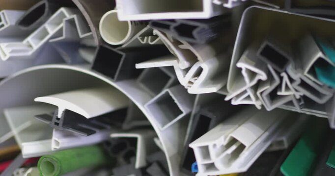 Detailed close up shot of various plastic and rubber profiles with different shapes and colors, showcasing materials for construction, sealing, and manufacturing industries