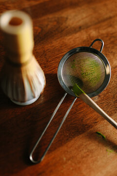 Traditional matcha preparation with whisk and sieve