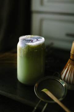 Refreshing matcha latte with bamboo whisk and strainer