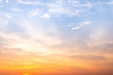 Fototapeta premium Beautiful sunrise sky with vibrant gradient orange and gold colors and soft blue, Clear atmosphere with wispy clouds. Peaceful, perfect for background and copy space, High resolution images