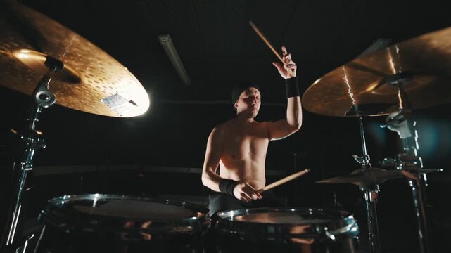 Rock band drummer playing drums during concert