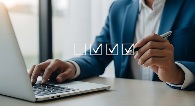 Businessman in blue suit using laptop and checking off items on virtual checklist with pen business success and productivity