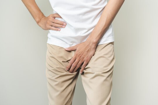 Closeup annoying itch asian man with an itchy his jock and butt, male scratching crotch with his hand, itching groin, male suffering body problem. Health care, hygiene, skin disease, medicine concept.
