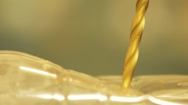 Dull drill bit failing to drill through plastic surface during repair process. Power tool pressing against transparent plastic without penetration in workshop environment. Maintenance and production