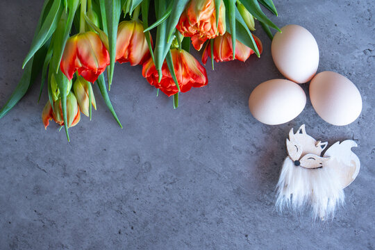 easter eggs, fox and tulips on grey background