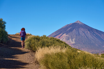 Fototapeta premium Woman hiking trail toward Mount Teide