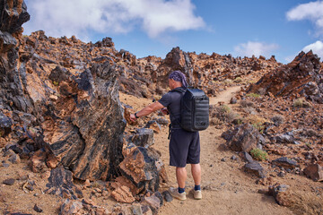 Fototapeta premium Hiker filming obsidian rock on Teide