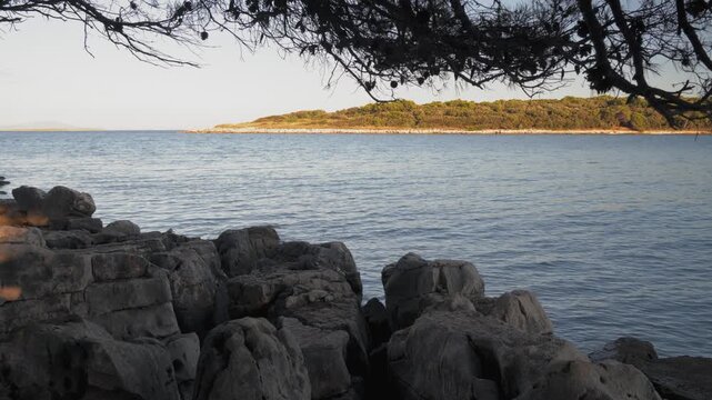 Rocky Seashore with Calm Blue Sea and Island View
