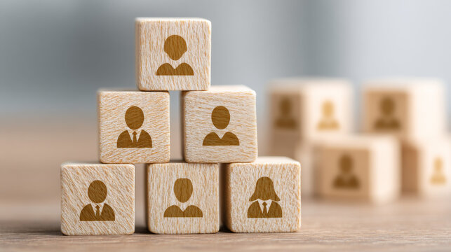 Light wooden cubes with golden people icons in pyramid formation for team building and leadership
