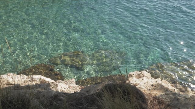 Transparent sea water flowing above coastal rocks
