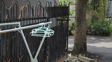 Clothes hangers made of plastic are attached to clotheslines made of aluminum.