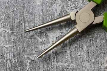 Close-up of round-nose pliers on a gray background