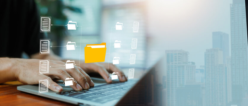Digital document management and file organization concept with folder icon network over laptop keyboard. Business data storage, cloud archive system, information workflow paperless office technology.