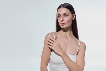 Fototapeta premium Beautiful young woman poses gracefully in soft light showcasing elegance and natural beauty