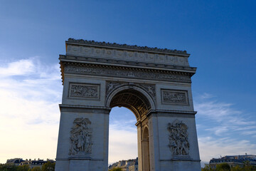 Fototapeta premium Majestic low-angle view of the Arc de Triomphe in Paris at dusk under a clear blue sky