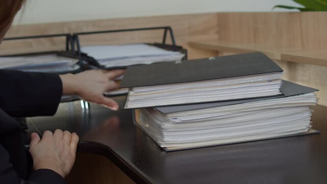 Stack of document folders on office desk with paper tray