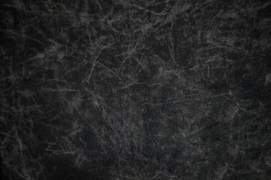 Dark black acid wash denim fabric texture background for design.