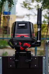 Outboard motor in the showroom: close-up of the hull and tiller.