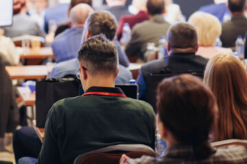 Obraz premium Conference, hall with audience, panel discussion at forum, people on a congress together listen to speaker on stage at convention, plenary session at business lecture seminar, venue for presentation
