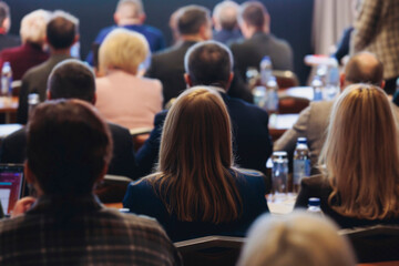 Obraz premium Conference, hall with audience, panel discussion at forum, people on a congress together listen to speaker on stage at convention, plenary session at business lecture seminar, venue for presentation