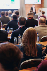 Obraz premium Conference, hall with audience, panel discussion at forum, people on a congress together listen to speaker on stage at convention, plenary session at business lecture seminar, venue for presentation