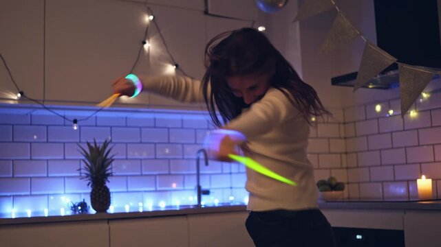 Cheerful Child Performs Playful Dance Moves At Home, Wearing Colorful Luminous Neon Wristbands