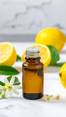 Amber bottle with white flowers & lemons against white marble background, natural lighting