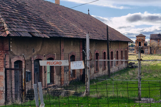 View of weathered bricks and peeling paint whisper tales of industry past at the old coal loading facility, under a cloudy sky, Puertollano, Castile-La Mancha, Spain.