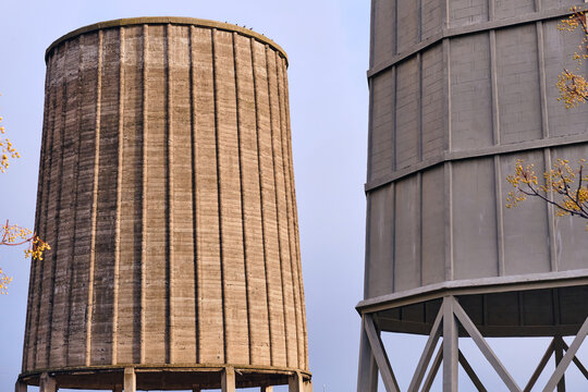 View of imposing concrete structures rise against the muted sky, their textured surfaces hinting at industrial history, Puertollano, Castile-La Mancha, Spain.