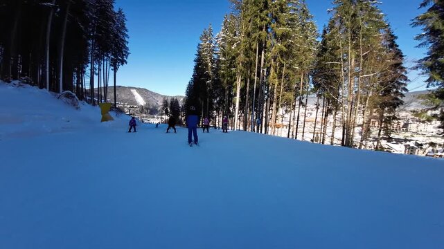 First person fast motion of skier skiing on slope in ski resort, enjoying beautiful landscape of mountains covered with snow in sunny winter day. Concept of active sport. Bukovel ski resort, Ukraine. 