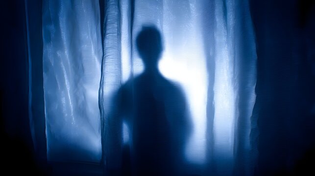 Mysterious silhouette of a person standing behind a translucent curtain, illuminated by a blue light, creating an eerie and suspenseful atmosphere.