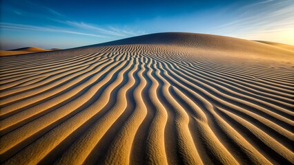 Naklejka premium Rippling Sand Dunes Under a Clear Blue Sky at Sunset desert ripples